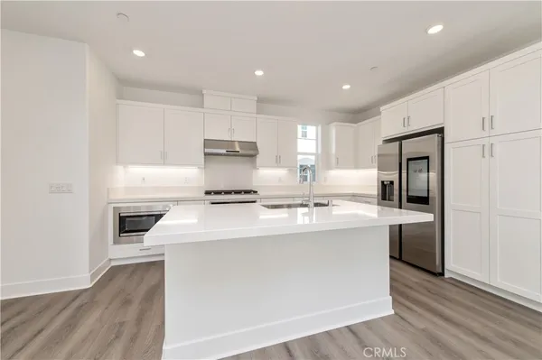 a kitchen with kitchen island a sink stainless steel appliances and cabinets