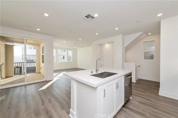 a kitchen with a sink and wooden floor