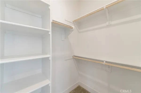 a view of walk in closet with empty racks