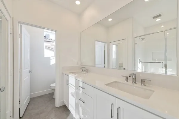 a bathroom with a sink double vanity granite tub and a mirror