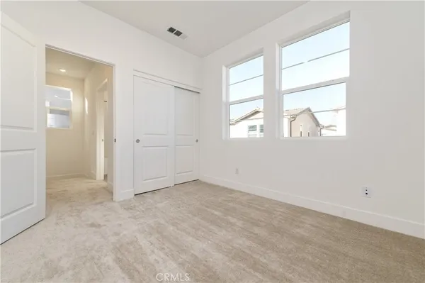 an empty room with windows and closet