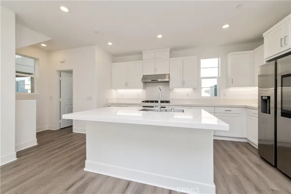 a kitchen with kitchen island sink stove and refrigerator