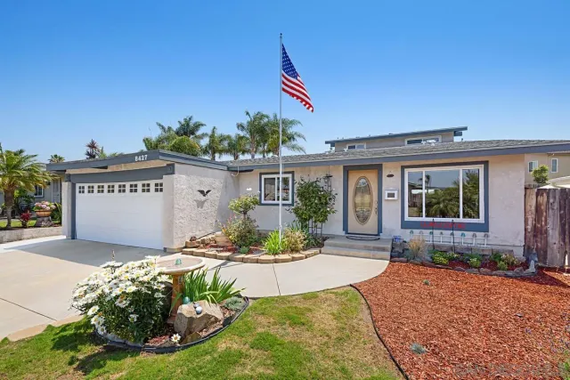 a front view of a house with a yard outdoor seating and garage