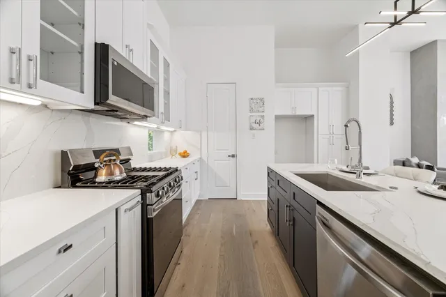 a kitchen with stainless steel appliances granite countertop a sink stove and refrigerator