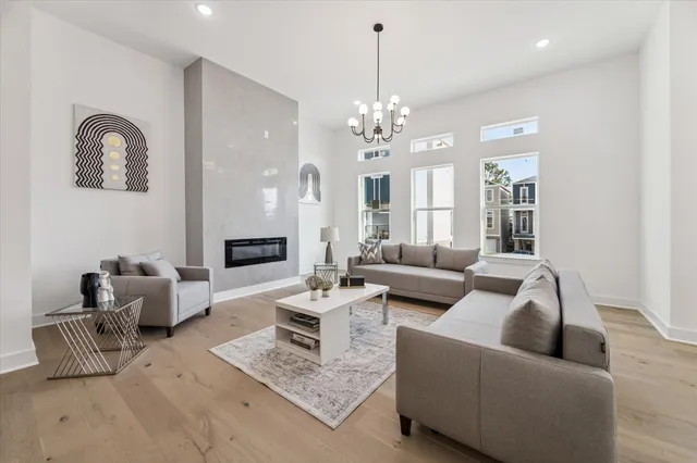 a living room with furniture or chandelier and a wooden floor