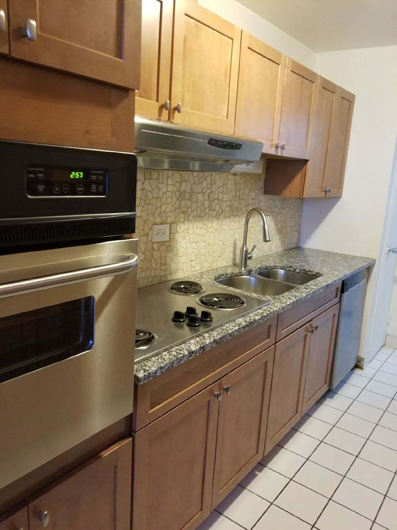 6301 North Sheridan Road, Unit 11B Chicago, IL 60660 - Photo 3 of 7 a kitchen with granite countertop a stove and a sink