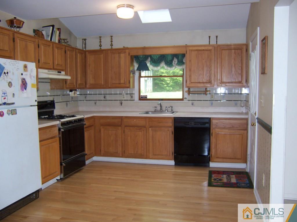 163 Kimberly Road Colonia, NJ 07067 - Photo 3 of 22 a kitchen with a sink cabinets and window