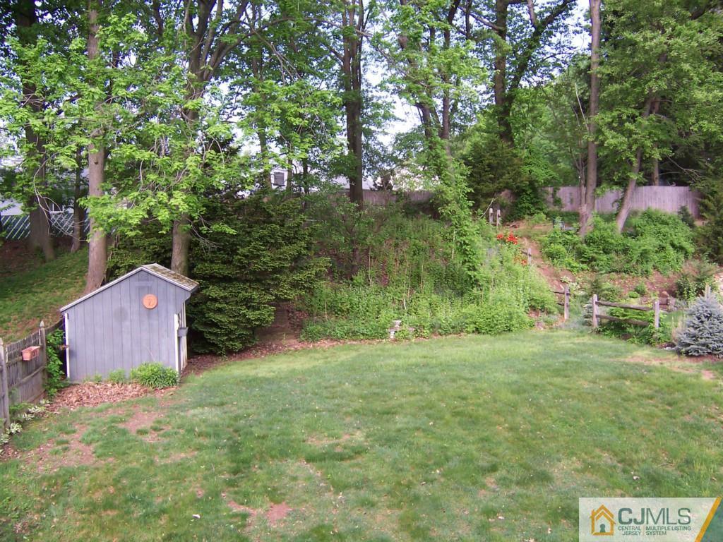 163 Kimberly Road Colonia, NJ 07067 - Photo 22 of 22 a backyard of a house with lots of green space and fountain