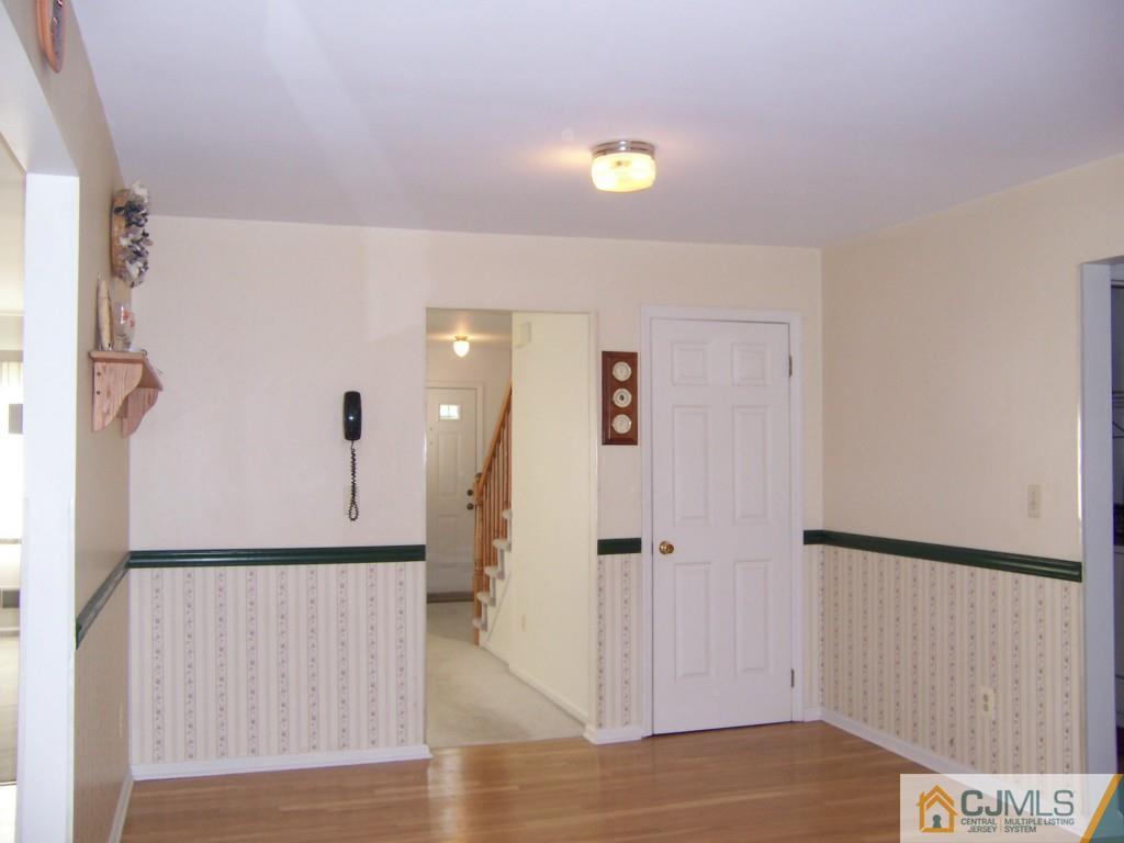 163 Kimberly Road Colonia, NJ 07067 - Photo 4 of 22 a view of a hallway to a bedroom with wooden floor and windows