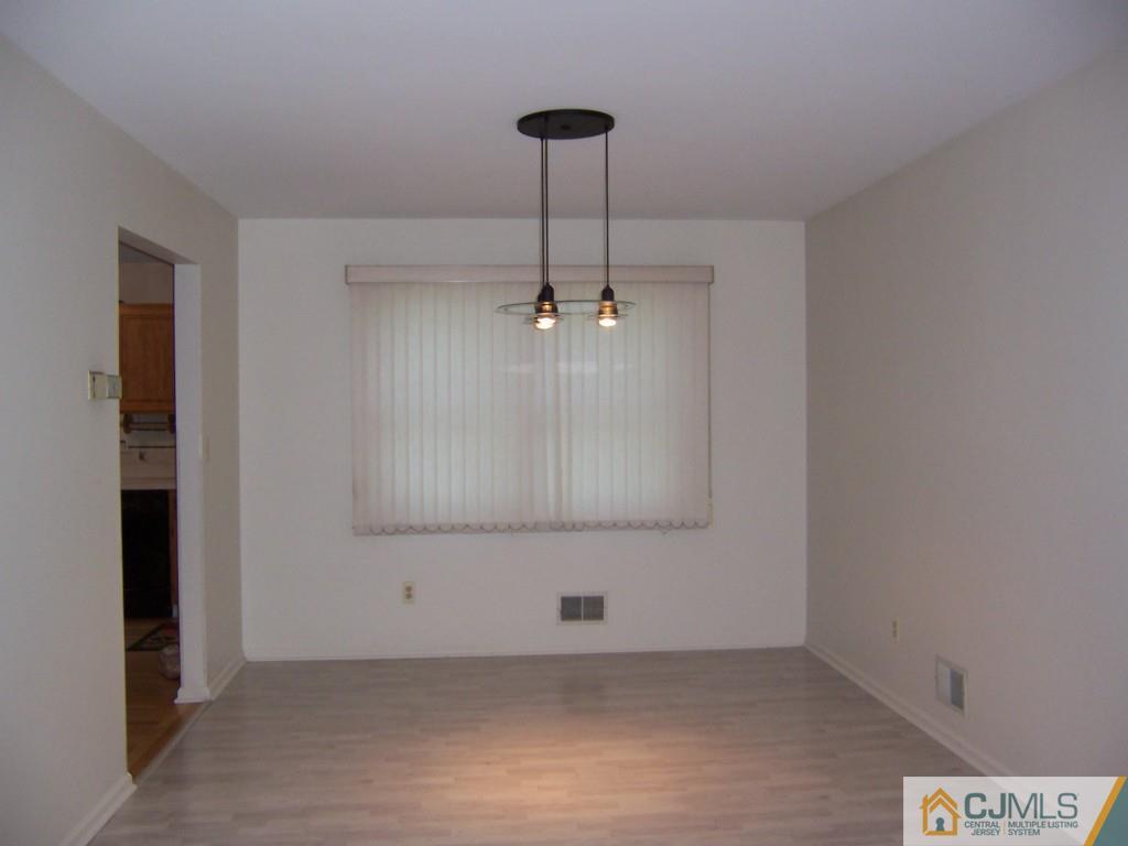 163 Kimberly Road Colonia, NJ 07067 - Photo 5 of 22 an empty room with cabinet and a chandelier fan
