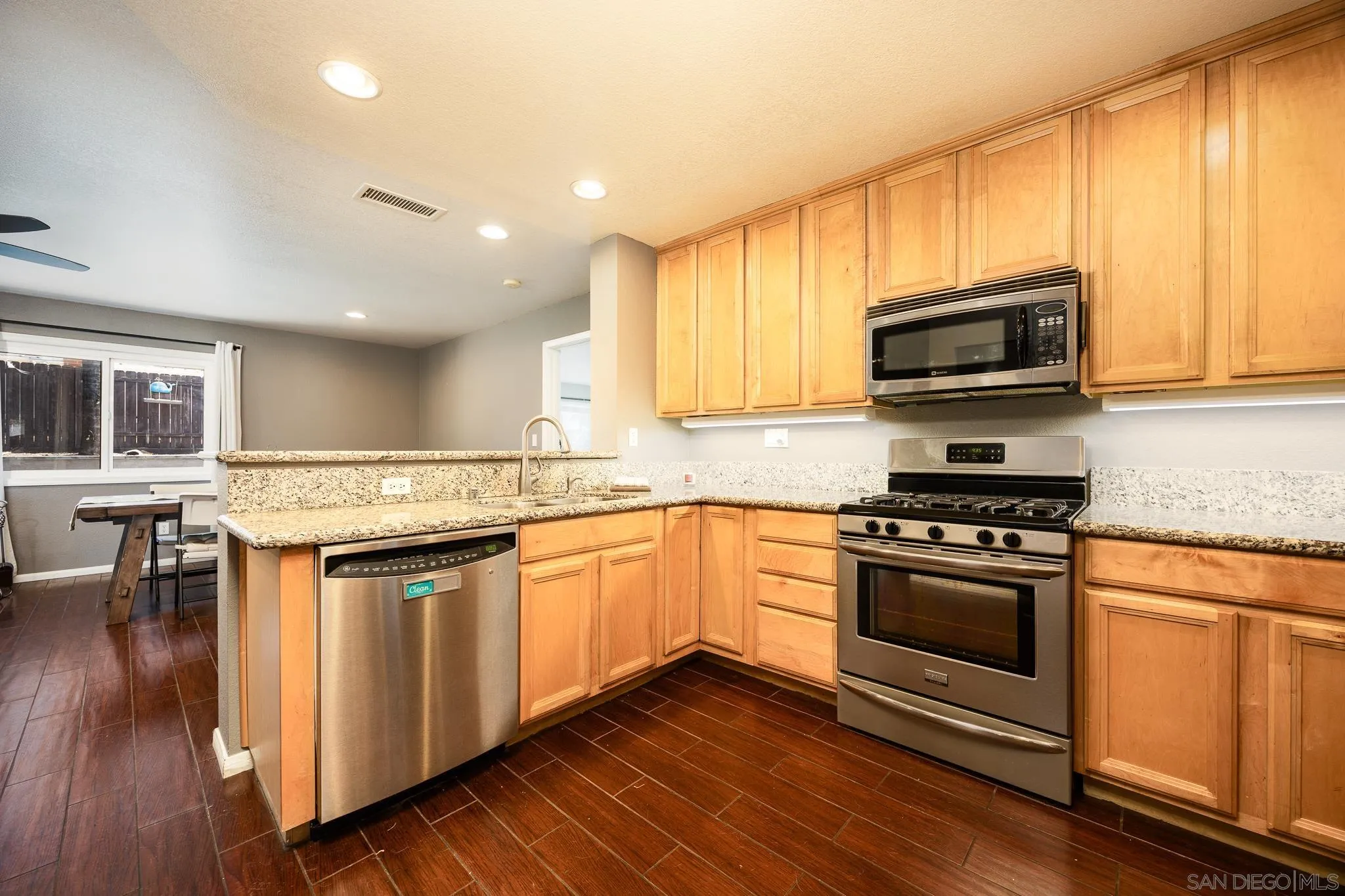 9276 Ruffin Road Santee, CA 92071 - Photo 13 of 40 a kitchen with stainless steel appliances granite countertop a stove a sink and a microwave