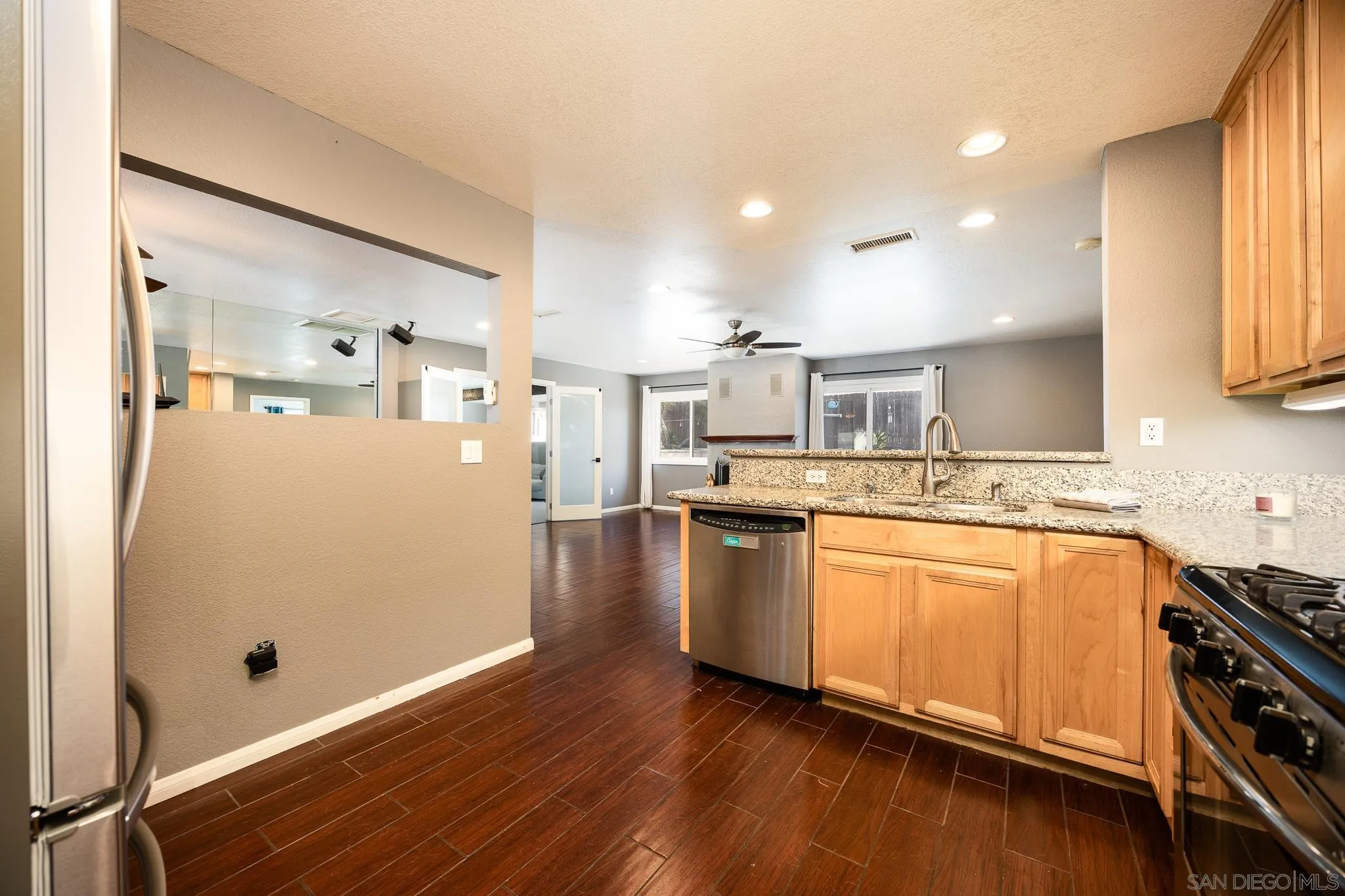 9276 Ruffin Road Santee, CA 92071 - Photo 14 of 40 a kitchen with stainless steel appliances granite countertop a refrigerator a stove and a sink with wooden floor