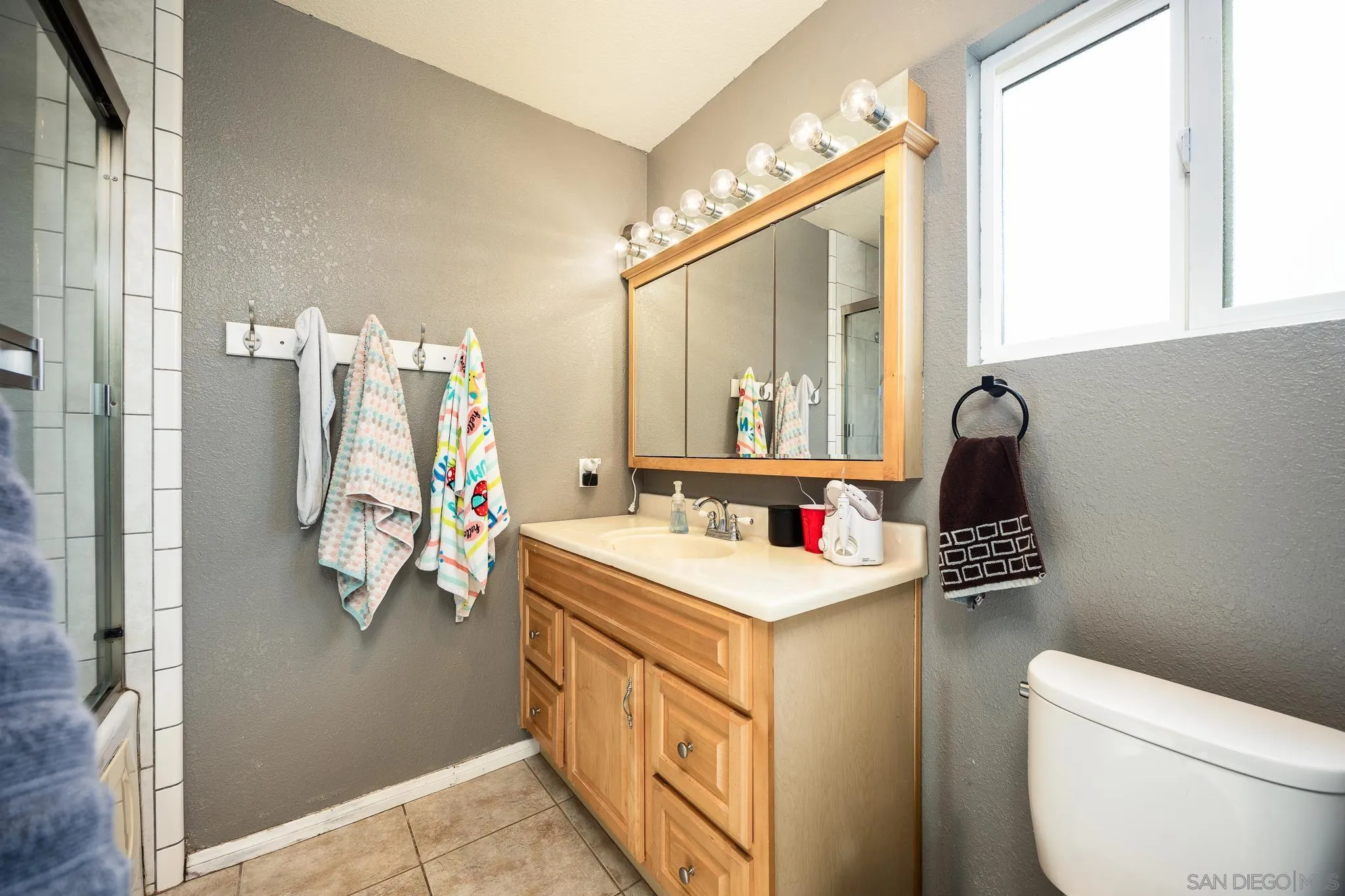 9276 Ruffin Road Santee, CA 92071 - Photo 18 of 40 a bathroom with a sink vanity mirror and toilet