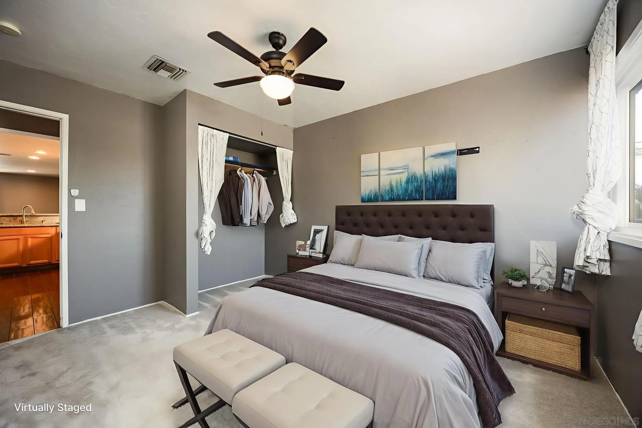 9276 Ruffin Road Santee, CA 92071 - Photo 25 of 40 a bedroom with a large bed and a chandelier