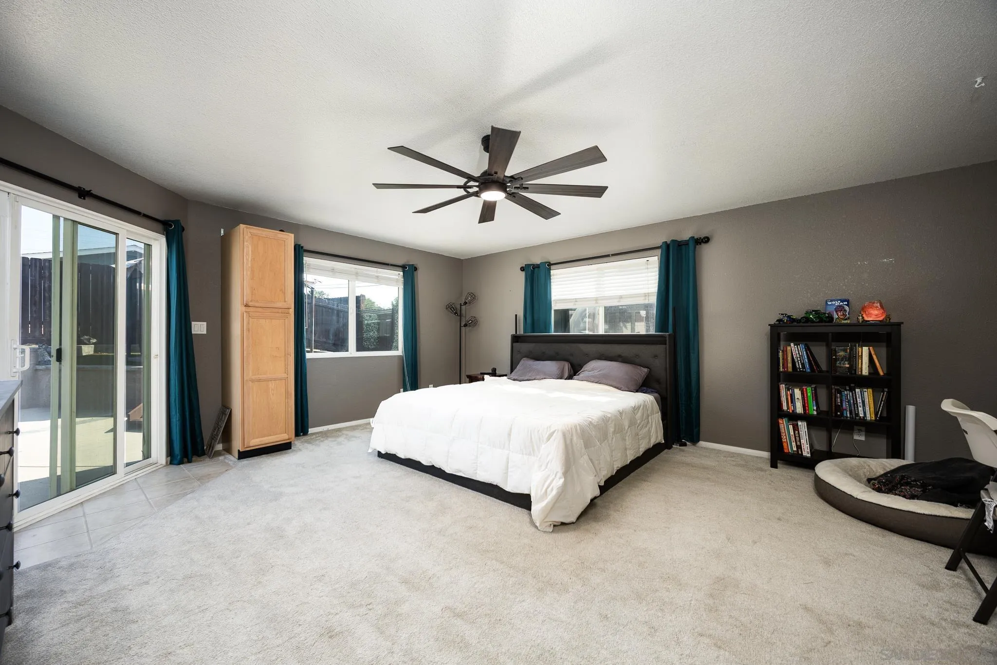 9276 Ruffin Road Santee, CA 92071 - Photo 4 of 40 a spacious bedroom with a large bed and a chandelier