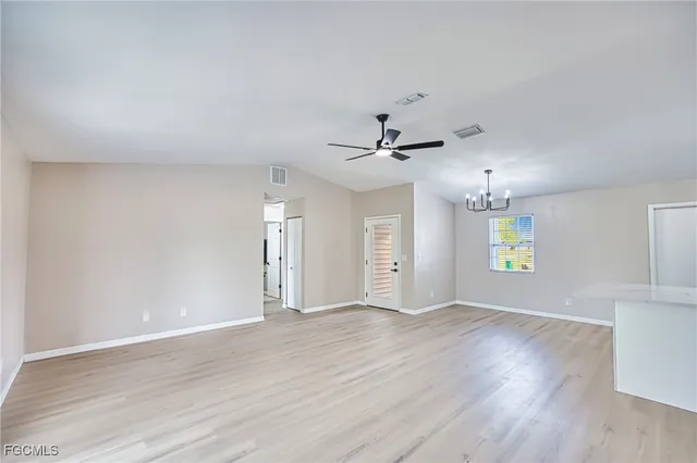 a view of an empty room with window and wooden floor