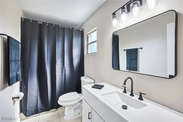 a bathroom with a sink toilet mirror and shower