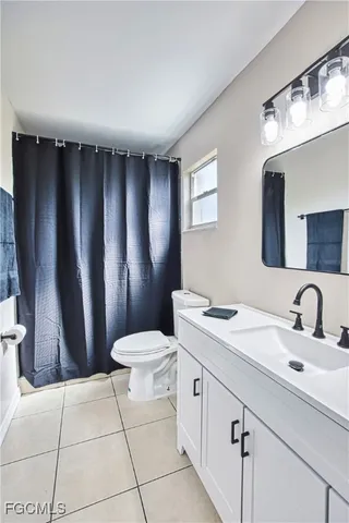 a bathroom with a sink a toilet a mirror and vanity