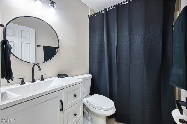 a bathroom with a toilet sink vanity and mirror