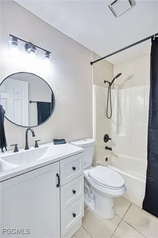 a bathroom with a toilet sink vanity granite and shower