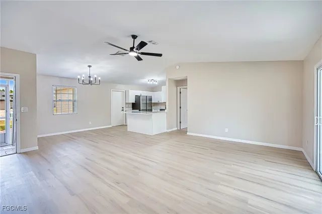 a view of empty room with wooden floor and ceiling fan