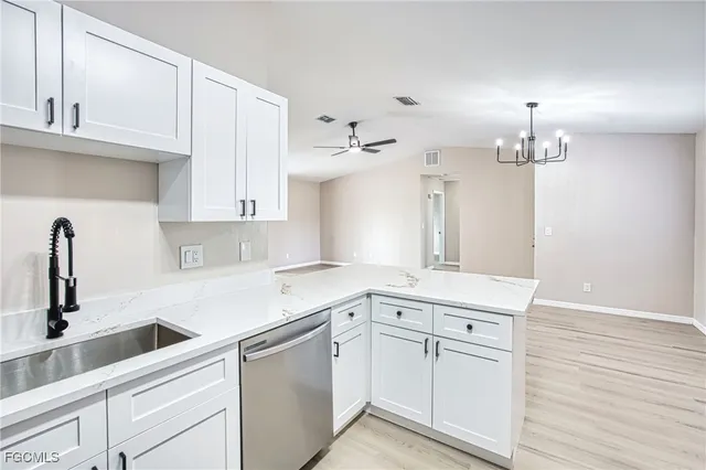 a kitchen with white cabinets appliances and a sink
