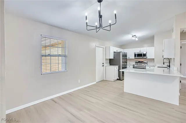 a view of kitchen with stainless steel appliances granite countertop a refrigerator a stove a sink dishwasher a microwave oven with cabinets and wooden floor