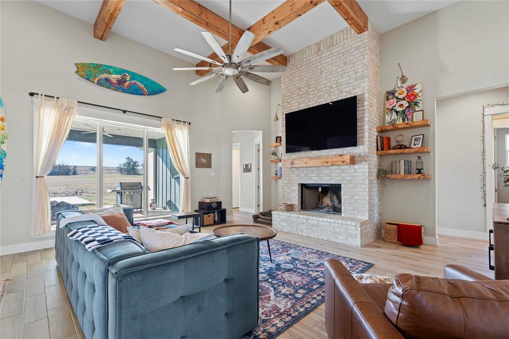2041 Carrie Court Weatherford, TX 76088 - Photo 5 of 36 a living room with furniture a flat screen tv and a fireplace