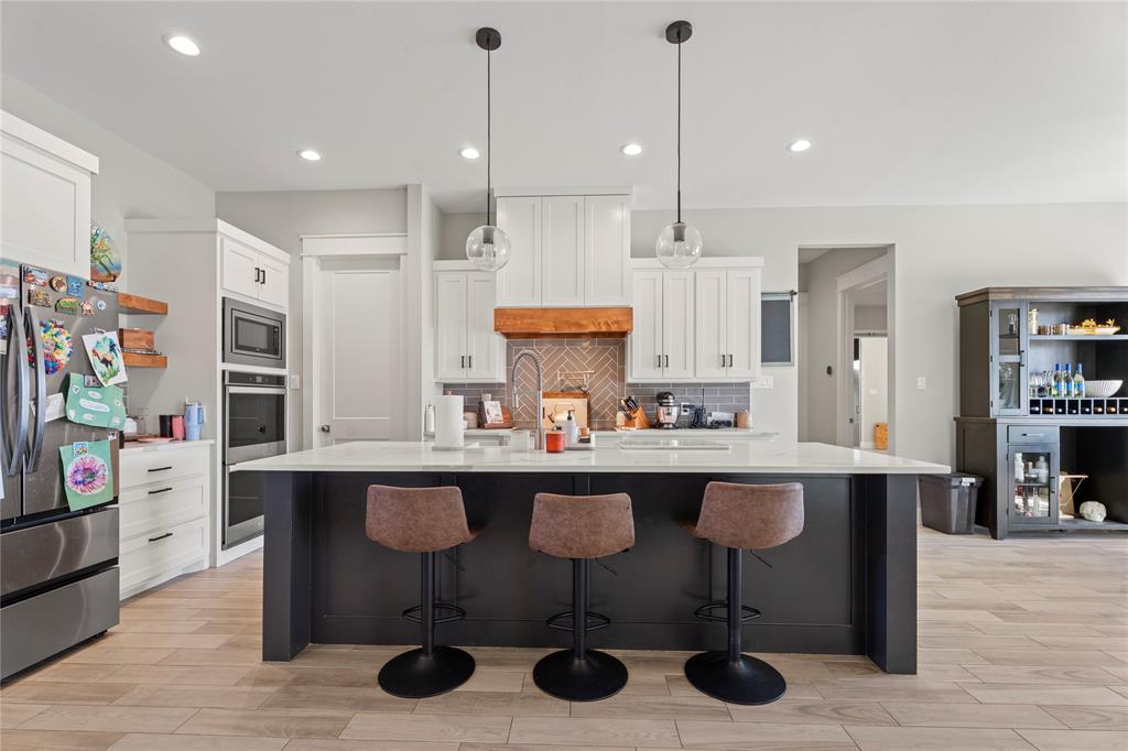 2041 Carrie Court Weatherford, TX 76088 - Photo 9 of 36 a kitchen with stainless steel appliances granite countertop a table chairs refrigerator and sink