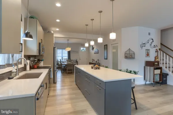 a large kitchen with kitchen island a sink a counter space and stainless steel appliances