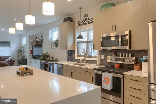 a kitchen with stainless steel appliances a stove a sink a oven and a refrigerator