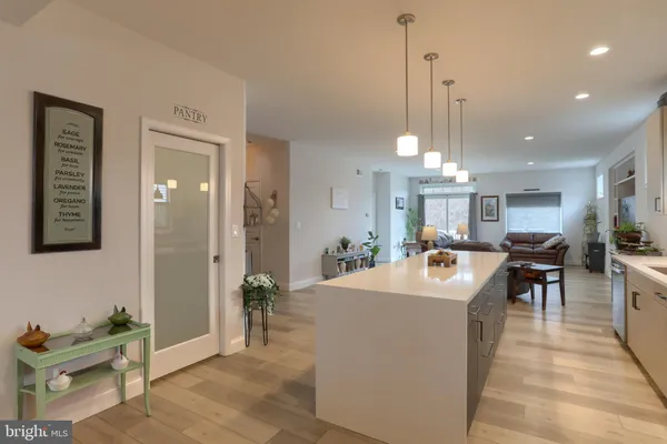 a view of a dining room and livingroom with furniture wooden floor a chandelier