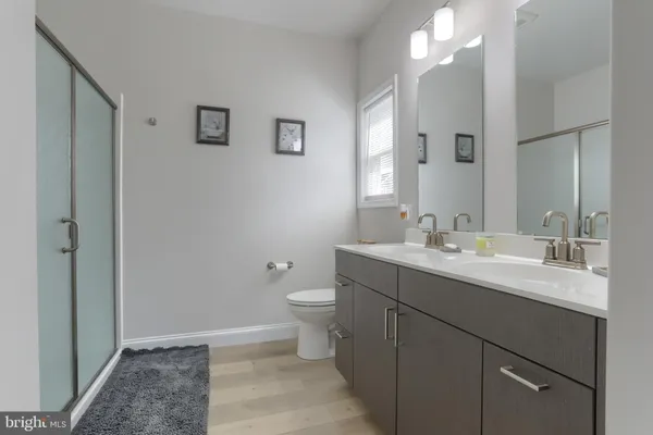 a bathroom with a double vanity sink toilet and a mirror