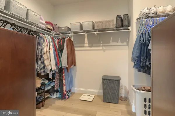 a view of walk in closet with clothes and shoes
