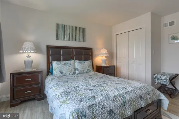a bedroom with a bed and a lamp on dresser
