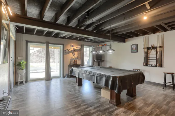 a view of an empty room with wooden floor and windows