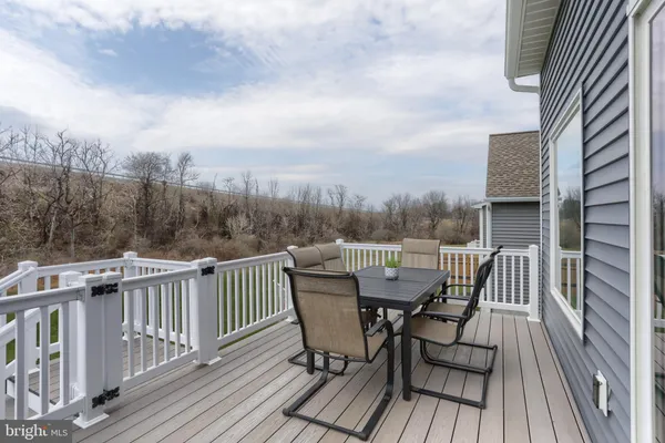 a view of a roof deck with table and chairs and wooden floor