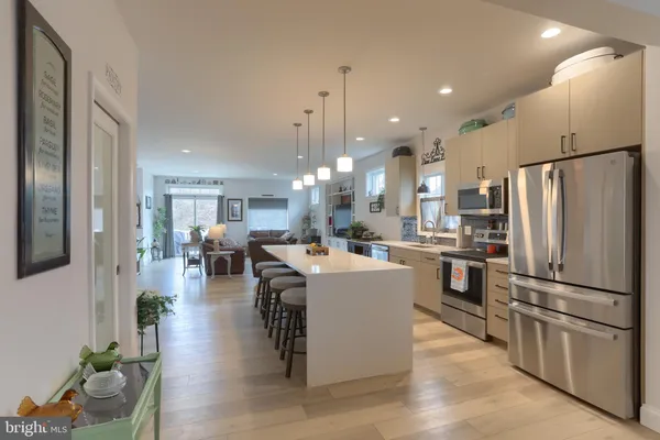 a large white kitchen with lots of counter space and stainless steel appliances
