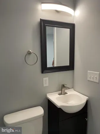a bathroom with a toilet sink and mirror