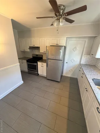 a kitchen with a stove a refrigerator and a cabinets