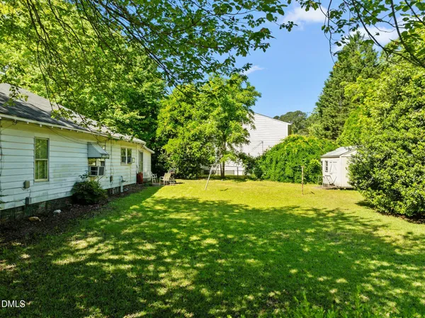 a view of backyard of house with green space
