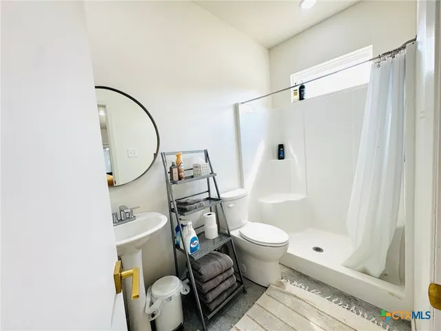a bathroom with a sink toilet and shower