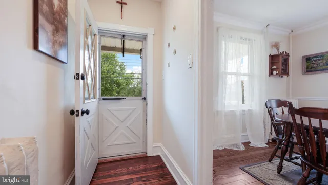 a view of a hallway to a livingroom with furniture and windows
