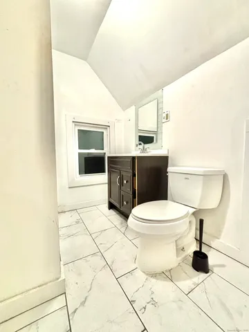 a large white kitchen with wooden floor