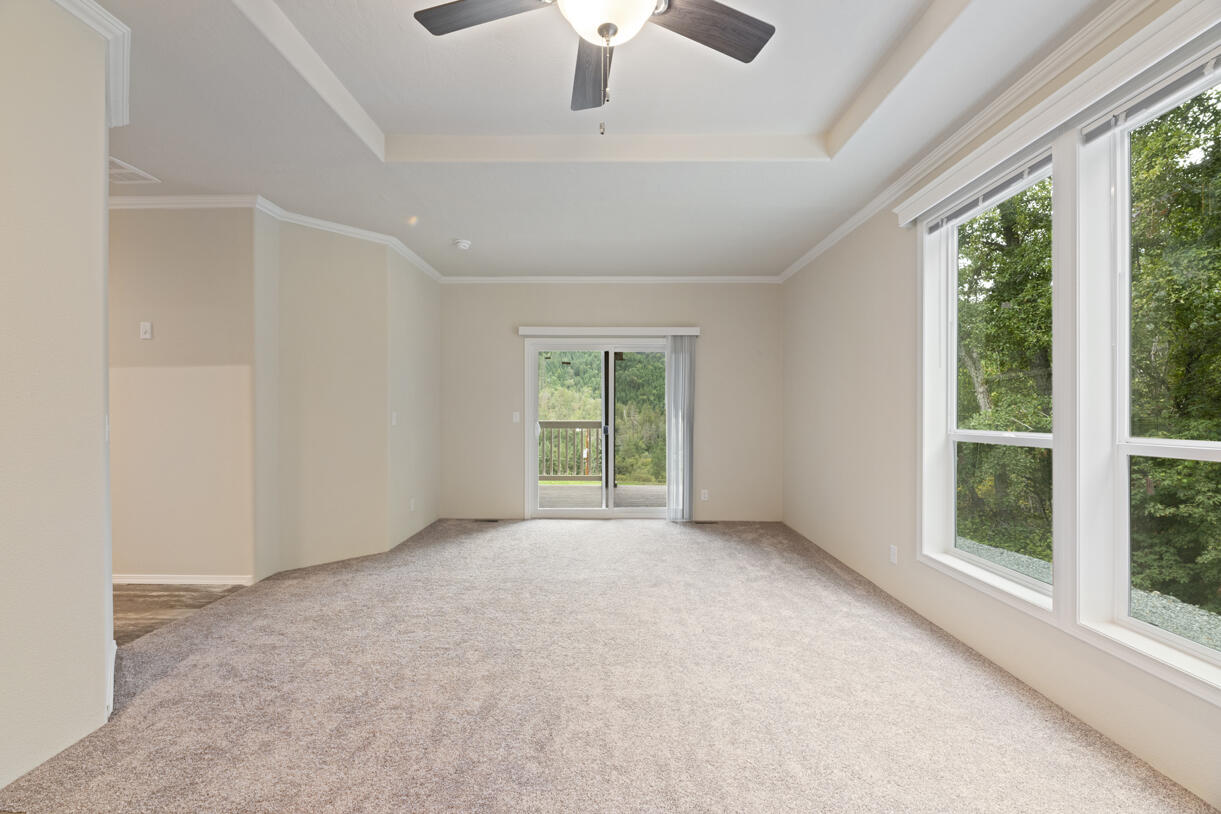 5572 Jumpoff Joe Creek Road Grants Pass, OR 97526 - Photo 5 of 38 a view of a livingroom with a ceiling fan and window