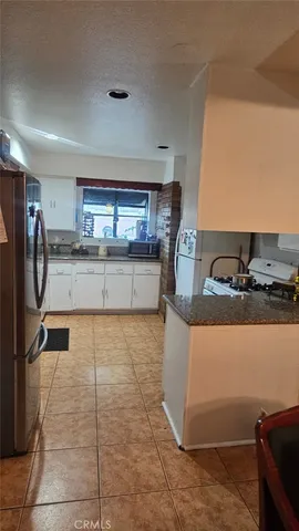 a kitchen with stainless steel appliances granite countertop a sink and a refrigerator