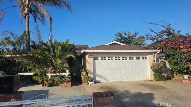 a view of a house with a yard and potted plants