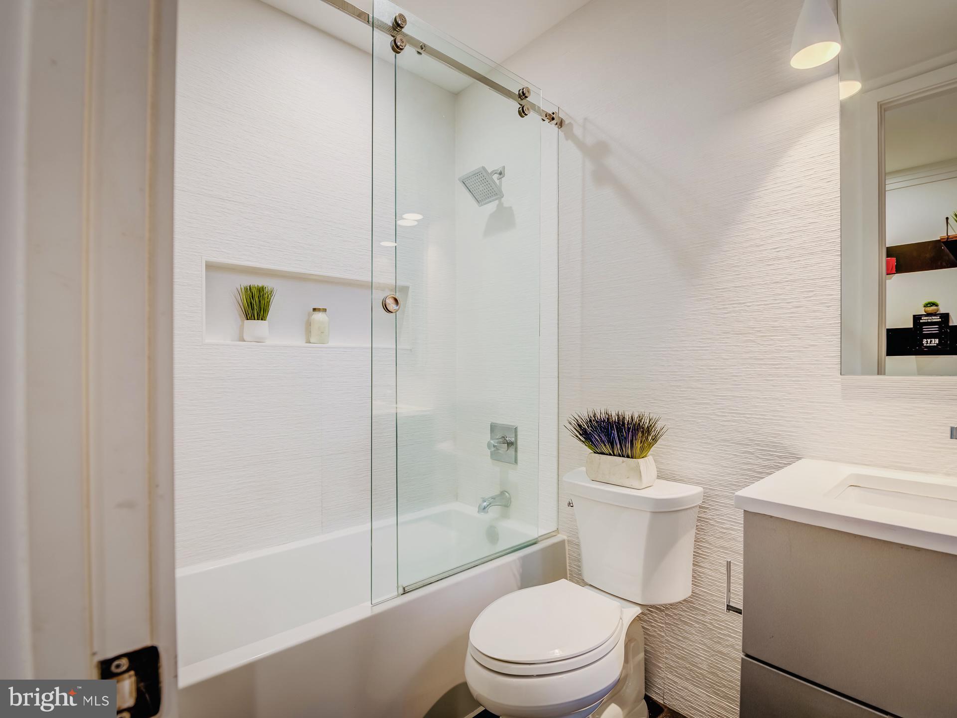 3527 14th Street Northwest, Unit 2 Washington, DC 20010 - Photo 12 of 19 a white toilet sitting next to a bath tub and a shower