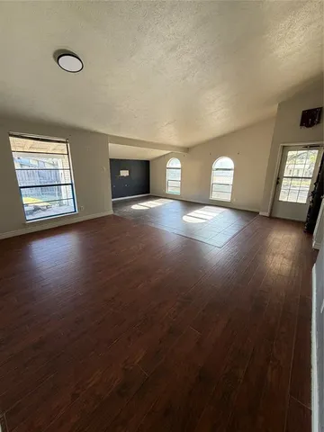 an empty room with windows and cabinet