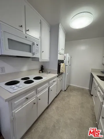 a kitchen with stainless steel appliances white cabinets and a stove